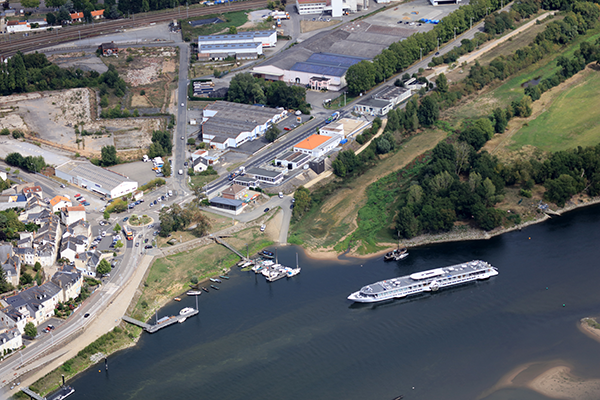 Vue aérienne zone d'activités en bord de Loire avec bateau de croisière fluviale